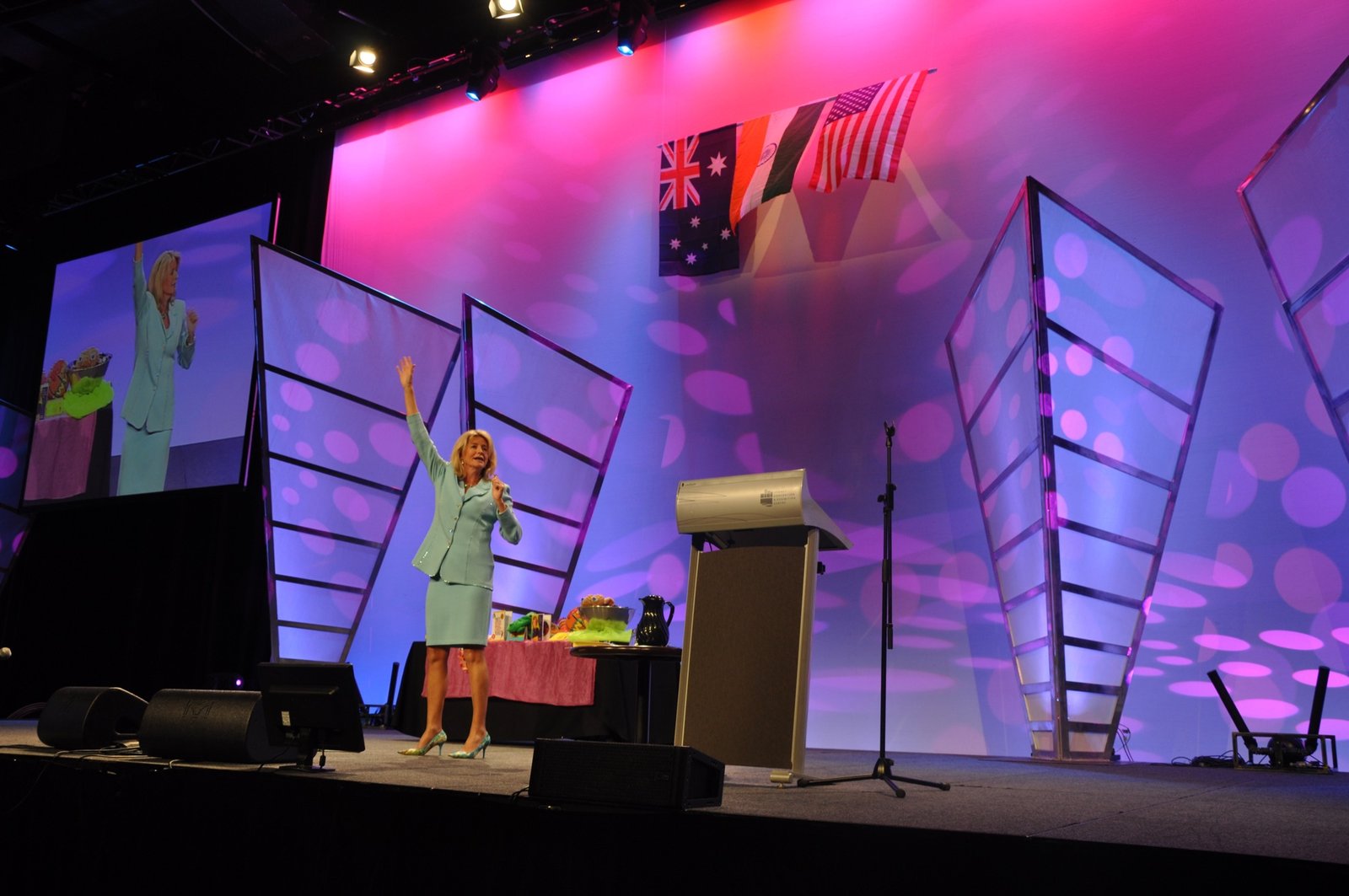 Lisa presenting on a colourful conference stage